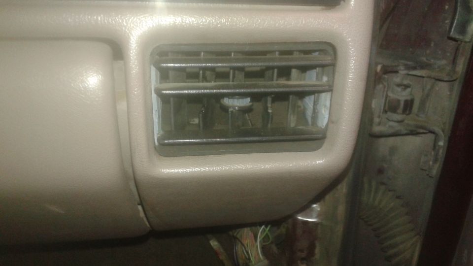 Dusty air vent with chrome trim on a vehicle dashboard.