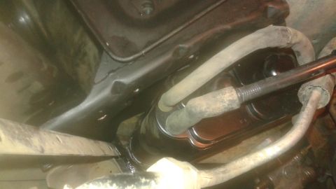 1996 Ford Bronco - A close-up view of the underside of a vehicle, focusing on the brake master cylinder and associated hoses. The master cylinder is black and…