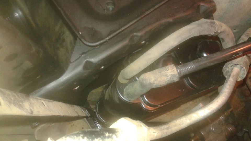 Underside view of a vehicle's brake master cylinder with hoses.