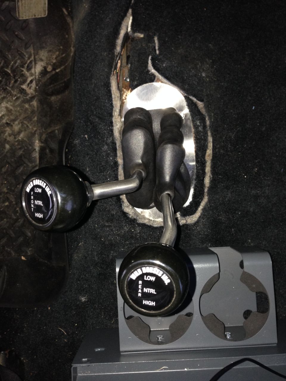 Dual transfer case shifters with 'Wild Horses Inc.' branding in a vehicle interior.