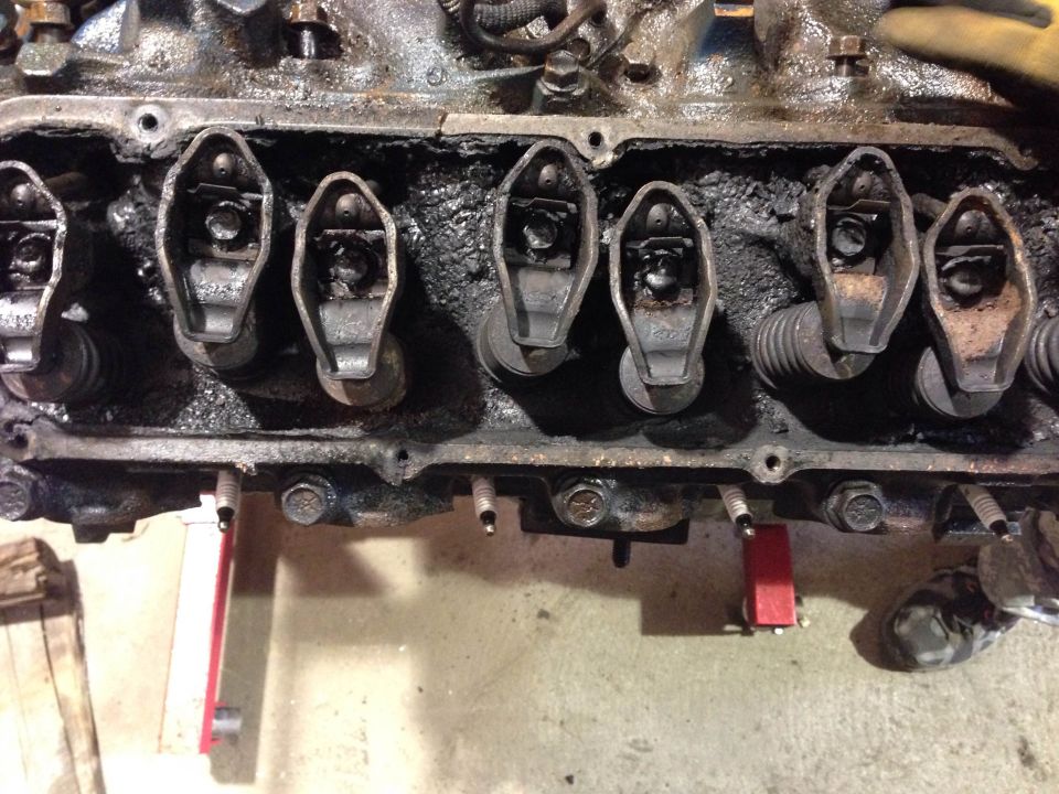 Overhead view of a dirty V8 engine showing rocker arms and valve springs.