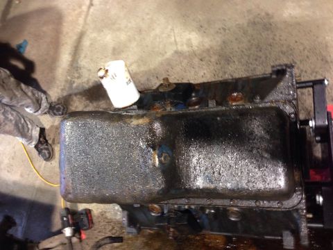 1979 Ford Bronco - Engine oil pan and filter assembly, likely in a workshop setting. Supermotors.net branding present.