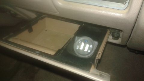 1996 Ford Bronco - A close-up view of a car's center console showing an open storage compartment and a dual USB charger port with "5V 2.1A" and "5V 1A" text v…