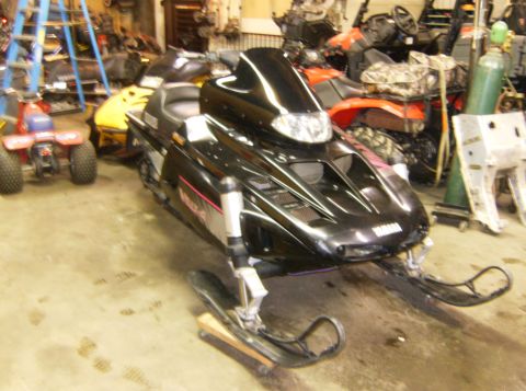 2000 Ford E350 - A black Yamaha snowmobile with a tall black windshield is parked indoors on a concrete floor. The snowmobile has pink and silver graphics o…