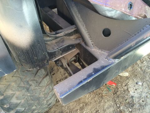 1987 Suzuki Samurai - Photo of a vehicle's rear frame corner, tire and bumper with a welded mounting bracket.