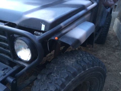 1987 Suzuki Samurai - Photograph of a vehicle front end with tubular brush guard and headlight, not a technical document.