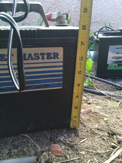 1987 Suzuki Samurai - Photograph of a battery with a brand label being measured, not a technical document.