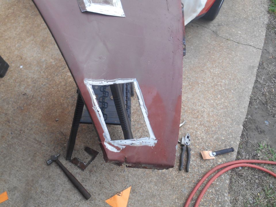 Car door panel with a cut-out, showing welding and tools.