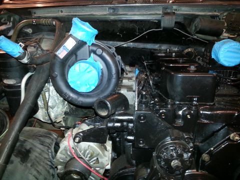1994 Ford Bronco - A close-up view of a diesel engine with a turbocharger. The turbocharger and some engine components are covered with blue protective tape.