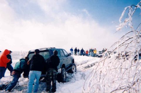 1978 Ford Bronco - A group of people attempt to free a vehicle stuck in a snowy, icy terrain.