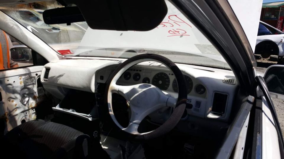 Interior of a white car showing dashboard, steering wheel, and driver's seat.