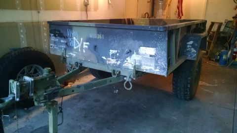 1979 Ford Bronco - A weathered, olive drab military-style trailer with camouflage paint is parked in a garage. Visible markings include "11401", "M20361", and…