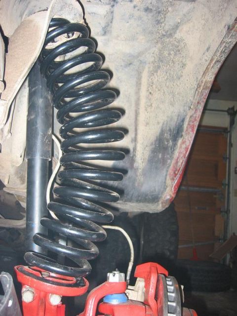 1985 Ford Bronco - This image shows the suspension system of a vehicle, focusing on the coil spring and shock absorber.