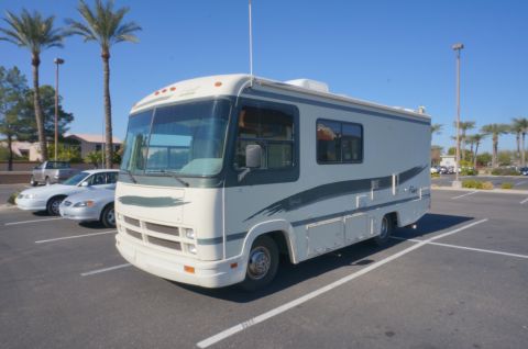 1995 Chevrolet P30 1 Ton - Step Van - Motorhome parked in a lot with other vehicles and palm trees.