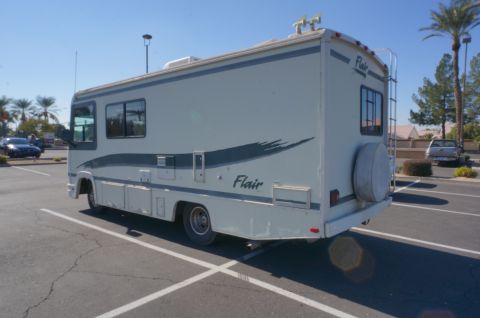 1995 Chevrolet P30 1 Ton - Step Van - A white RV with a spare tire mounted on the rear is parked in a lot.