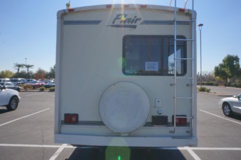 1995 Chevrolet P30 1 Ton - Step Van - Rear view of an RV with a ladder and spare tire mounted. The word 'Flair' is visible on the upper rear.