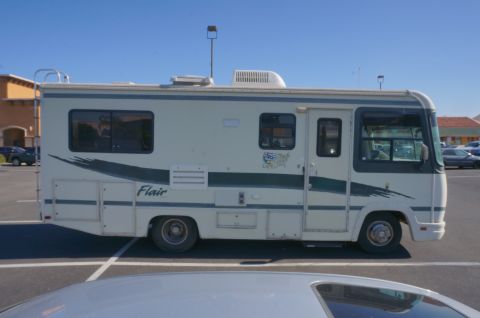 1995 Chevrolet P30 1 Ton - Step Van - Side view of a white motorhome with a green stripe and 'Flair' badging.