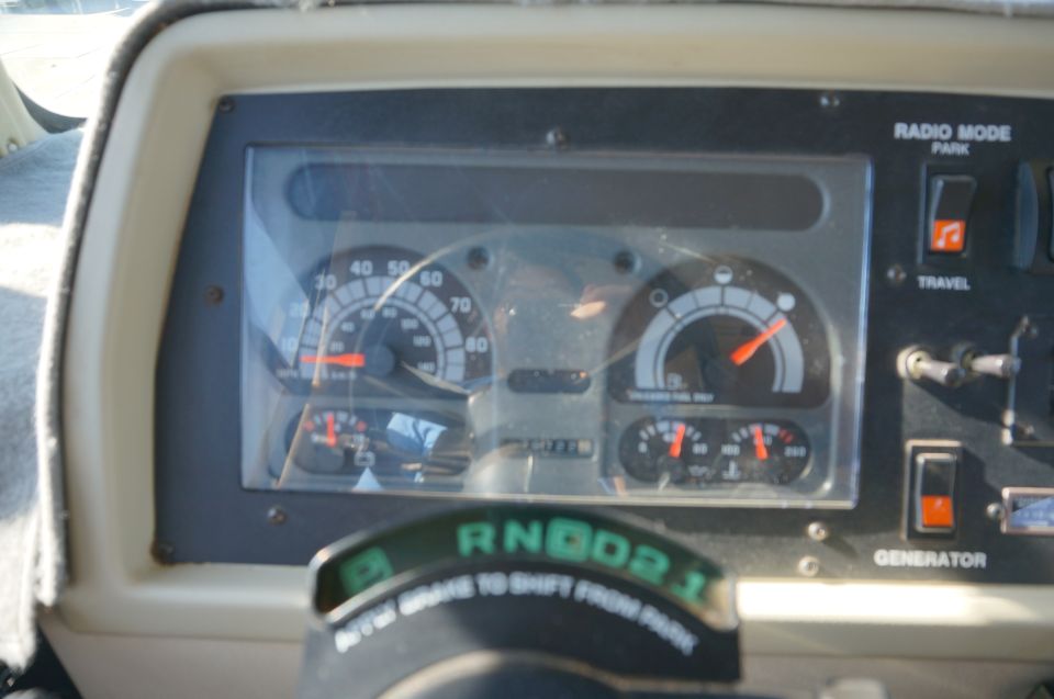 Dashboard with speedometer, fuel gauge, and various switches. Gear selector shows R, N, D, 2, 1