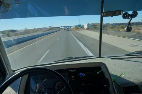 1995 Chevrolet P30 1 Ton - Step Van - View from the driver's seat of a motorhome or large van, looking down a highway. The dashboard with a steering wheel and radio is visible i…