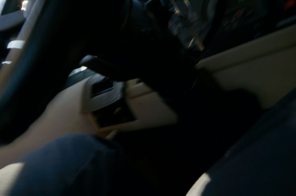 Interior of a step van showing steering column, dashboard, and legs in foreground.