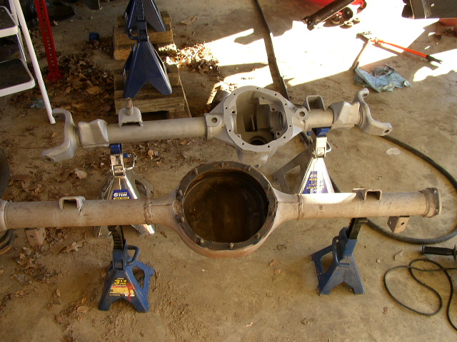 Two differential housings on jack stands, one clean and one rusty