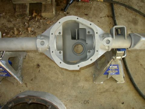 1995 Ford Bronco - Differential housing assembly supported by jack stands, with a portion of another part visible in the foreground.