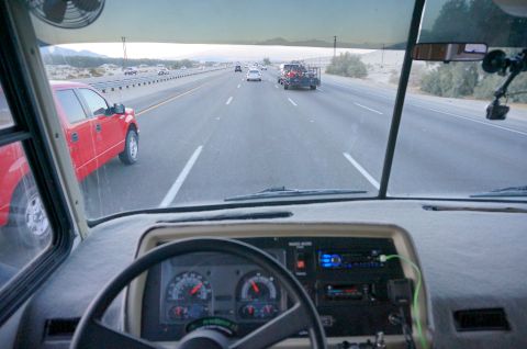 1995 Chevrolet P30 1 Ton - Step Van - View from the driver's seat of an RV driving on a highway. A red pickup truck is visible in the adjacent lane.