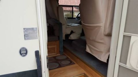 1995 Chevrolet P30 1 Ton - Step Van - View of the interior of a step van, showing the driver and passenger seats, and the entrance area with a door and a mat.