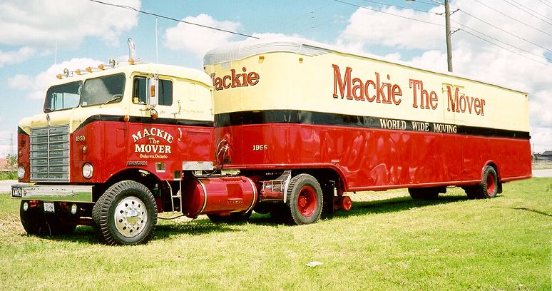 Red and cream semi-truck with a yellow and red trailer, side view. The trailer reads "Mackie The Mover"