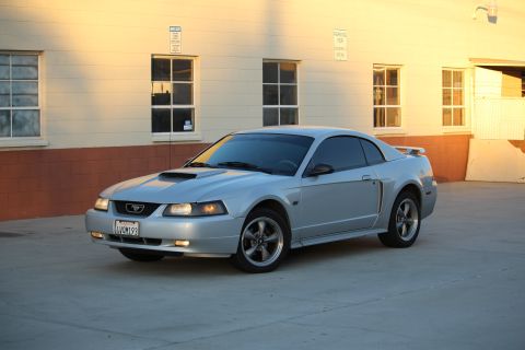 2002 Ford Mustang - Silver 2002 Ford Mustang coupe parked outside a building during golden hour.