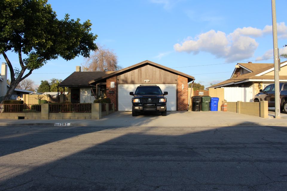 Black Ford F-150 pickup truck in front of a garage.