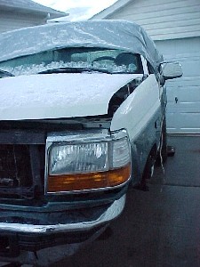 1996 Ford Bronco - 1996 Ford Bronco front view, partially covered with a tarp and snow.