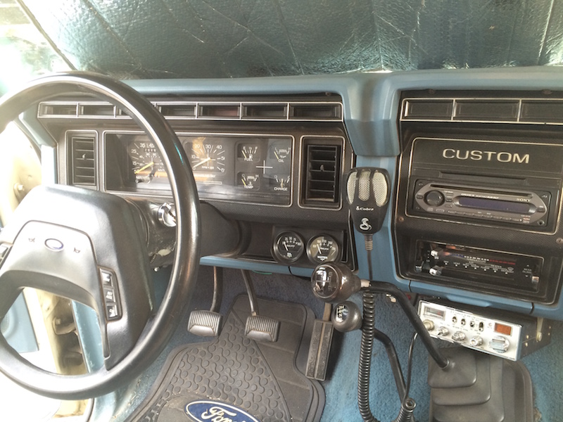 Interior of a 1981 Ford Bronco dashboard with steering wheel, Sony stereo, and CB radio.