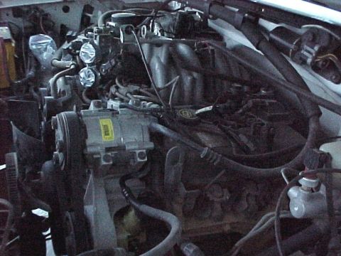 1996 Ford Bronco - Close-up view of a vehicle's engine compartment, showing various mechanical components and wiring.