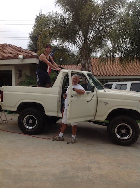 1981 Ford Bronco - Two men are posing with a cream-colored Ford Bronco. One man is standing in the bed of the truck, and the other is leaning against the open…