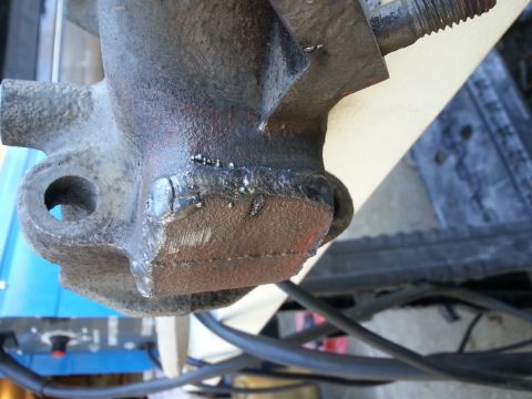 1994 Ford Bronco - A close-up view of a heavily welded metal component, likely a vehicle part, showing significant repair work with visible weld beads and som…