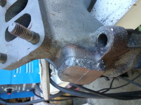 1994 Ford Bronco - A close-up view of a welded metal part, likely an engine component, with a threaded bolt visible. The part shows signs of rust and has been…