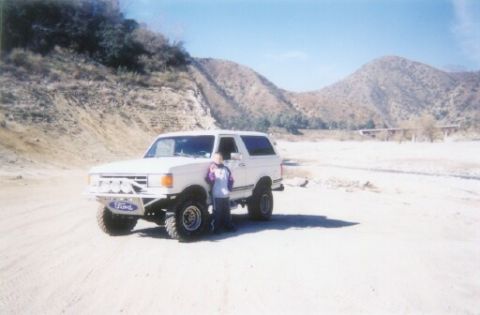 1988 Ford Bronco - 1988 Ford Bronco parked in a dry, mountainous area with a person standing next to it.