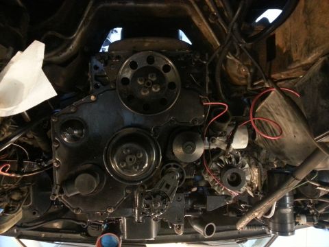 1994 Ford Bronco - An underside view of a vehicle's engine bay, focusing on the black engine block, pulleys, and alternator. Various hoses and wiring are visi…