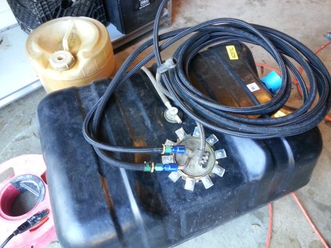 1994 Ford Bronco - A black plastic fuel tank with a braided fuel line assembly connected to the sending unit is shown. A yellow plastic gas can is also visibl…
