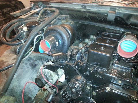 1994 Ford Bronco - A close-up view of a black diesel engine, likely from a 1994 Ford Bronco, showing a turbocharger, fuel injectors, and various hoses and lin…