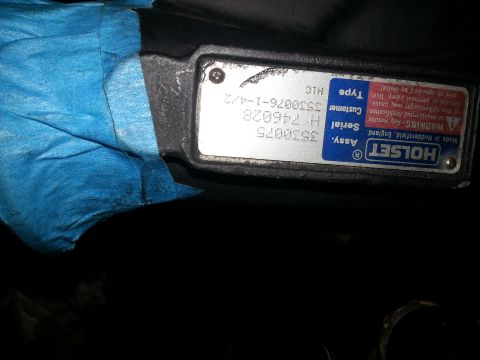 1994 Ford Bronco - A close-up of a metal identification plate on a vehicle part, possibly a turbocharger, with blue tape partially covering the left side. The…