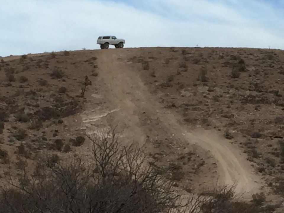 SUV driving up a dirt path on a hill