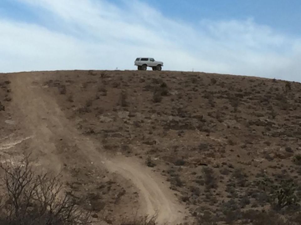 1979 Ford Bronco on a dirt hill under a blue sky
