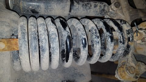 1995 Ford Bronco - Suspension coil spring and shock absorber assembly, showing wear and dust.