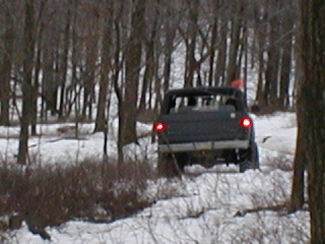1979 Ford Bronco II driving off-road in snow, rear view