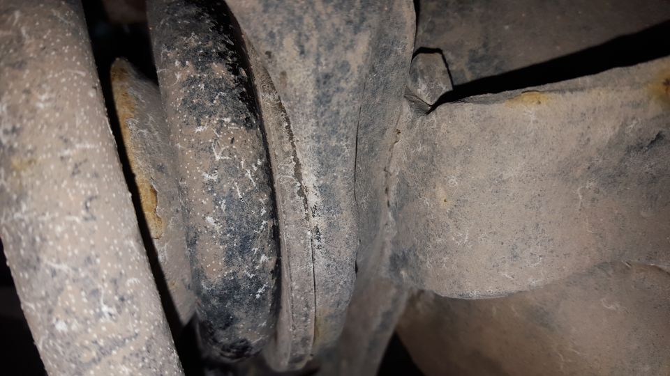 Close-up of dirty suspension parts, possibly springs and brackets