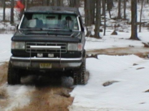 1979 Ford Bronco II - This black SUV, likely from the early 1980s, navigates a snowy terrain.