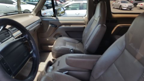 1995 Ford Bronco - The interior of a 1995 Ford Bronco features tan leather seats and a tan dashboard.