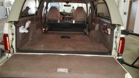 1995 Ford Bronco - The rear interior of a 1992 Ford Bronco is visible with the tailgate down.